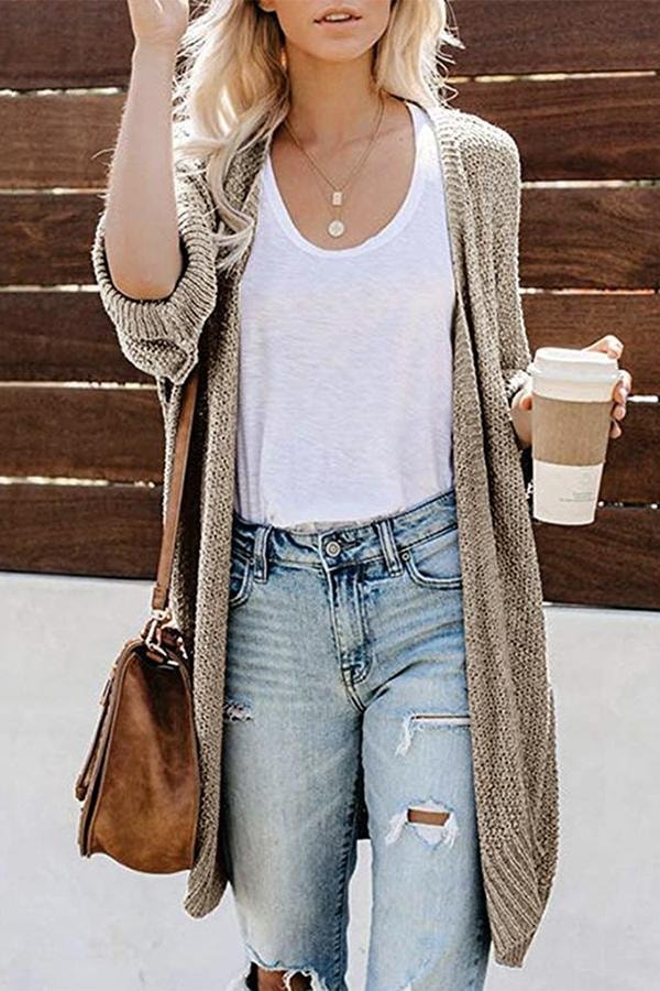 Cárdigan beige abierto de diseño largo, con mangas amplias y una combinación informal de camiseta y vaqueros.