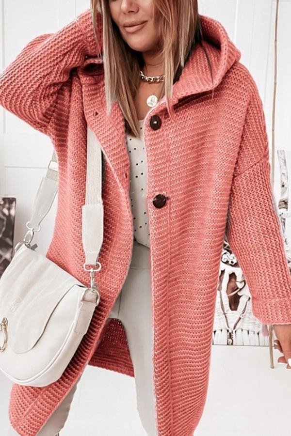 Cárdigan largo coral con capucha y botones oscuros, combinado con un bolso claro.