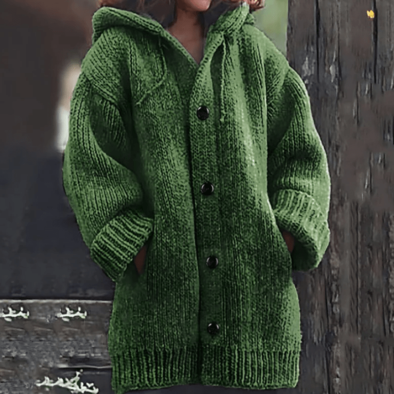 Cárdigan de punto grueso en color verde, con capucha, bolsillos delanteros y puños acanalados.