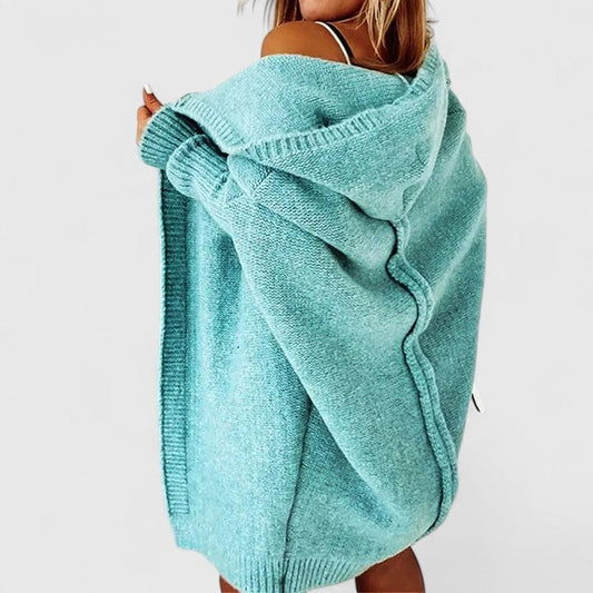 Cárdigan oversize turquesa con capucha visto desde atrás, con diseño abierto y mangas amplias.