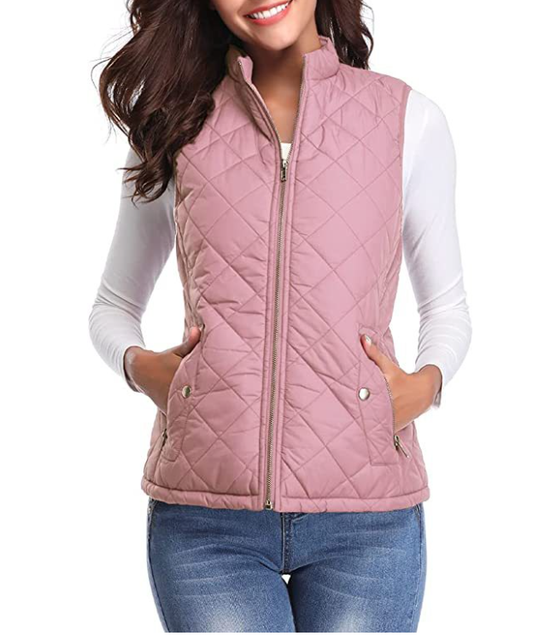 Chaleco acolchado rosa con cuello alto, cierre frontal y bolsillos laterales con broches, combinado con camiseta blanca y vaqueros.