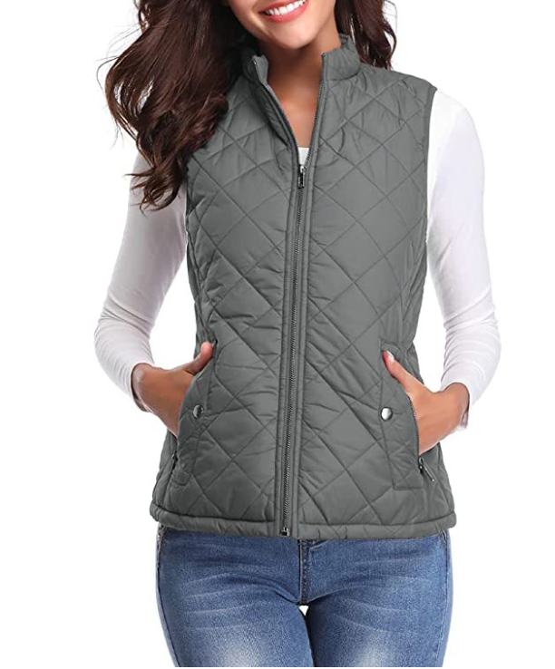 Chaleco acolchado gris con diseño de rombos, cuello alto y cierre frontal, mostrado con las manos en los bolsillos.