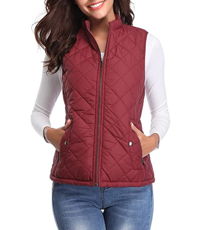 Chaleco acolchado burdeos con cuello alto y bolsillos laterales, llevado sobre una camiseta blanca.