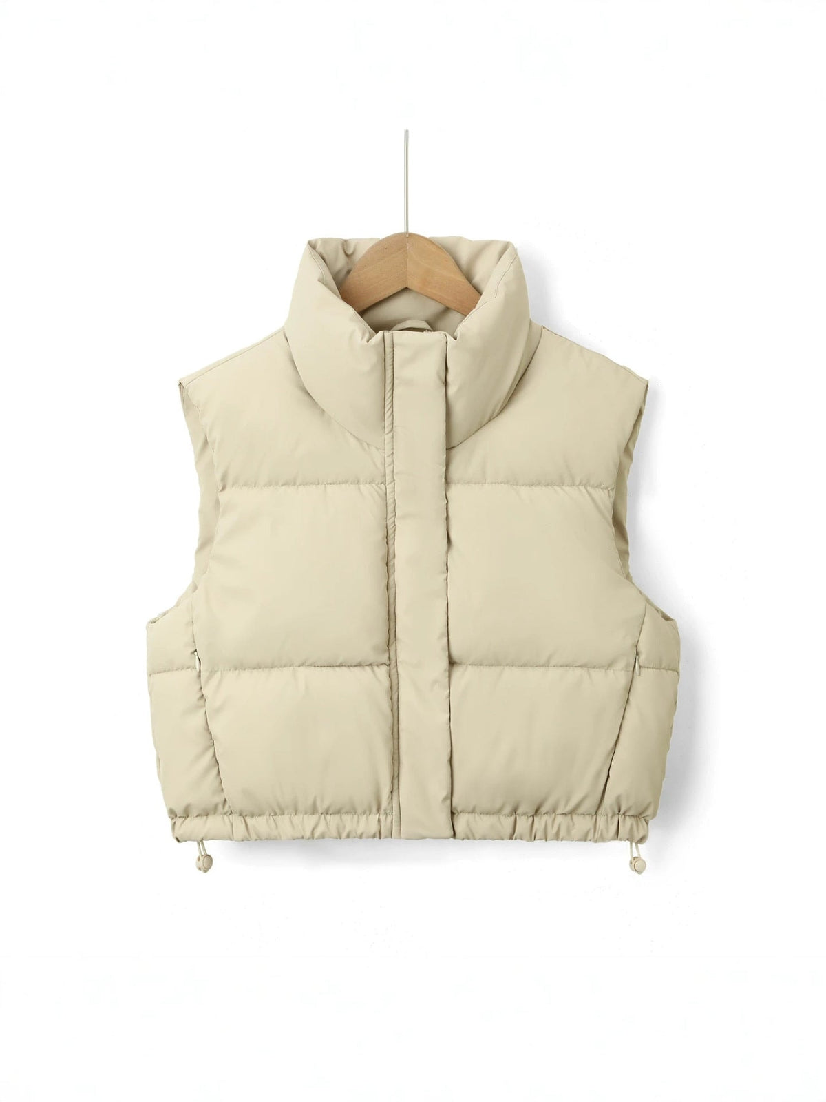 Chaleco acolchado corto en tono crema claro, con cuello alto envolvente, bolsillos laterales y bajo regulable.