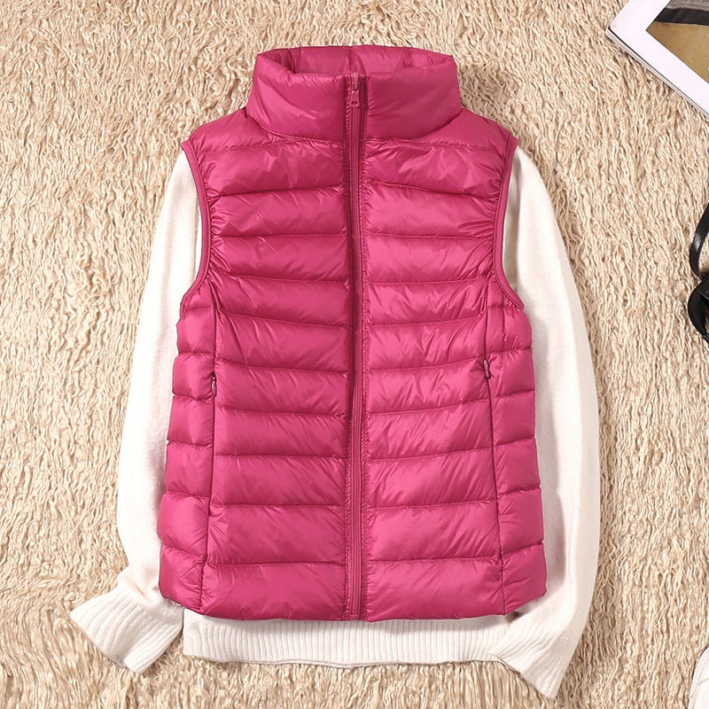 Chaleco acolchado fucsia colocado sobre un jersey claro, destacando su forma entallada y los laterales fruncidos.