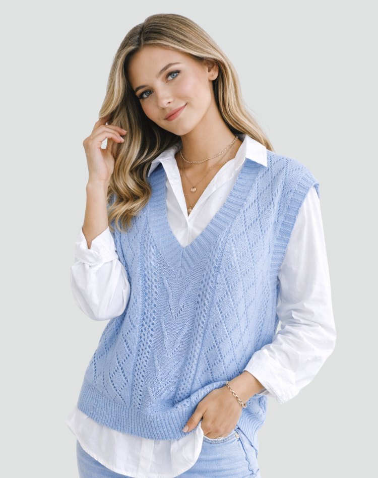 Chaleco azul claro de punto trenzado con escote en V, combinado con camisa blanca y vaqueros.