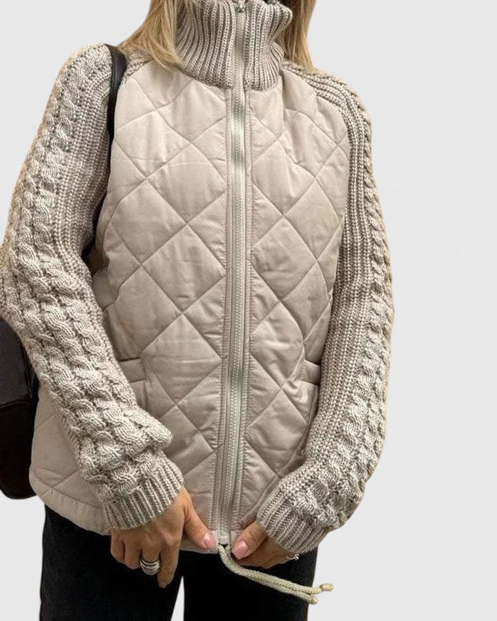 Vista frontal de la chaqueta clara cerrada, con panel acolchado de rombos, mangas de punto y cuello alto subido.