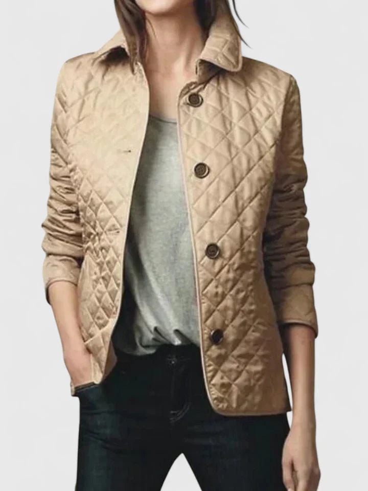 Chaqueta acolchada beige de silueta entallada, con cuello clásico y varios botones frontales visibles.