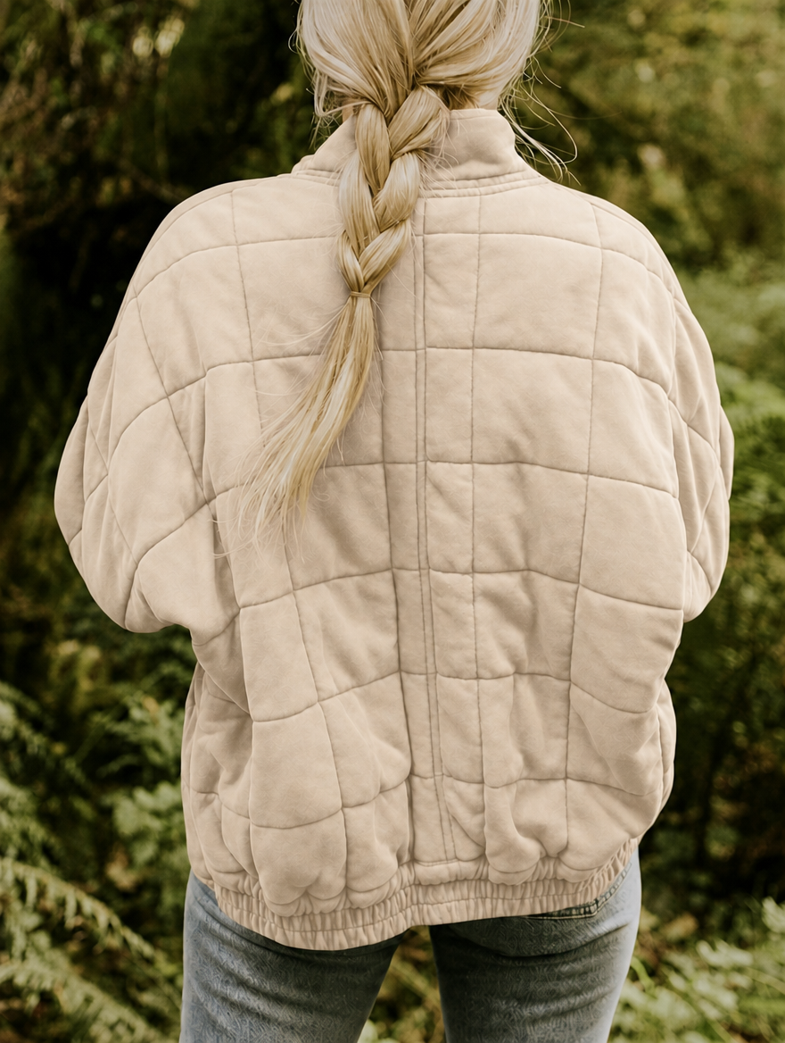 Vista posterior de la chaqueta acolchada beige, con diseño de cuadros y bajo elástico.