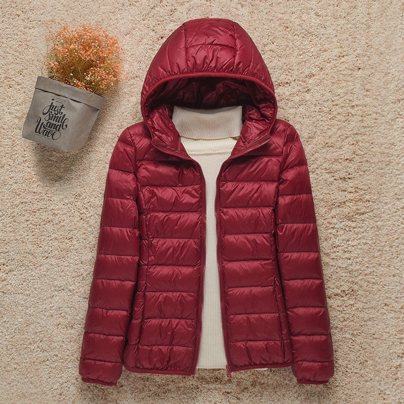 Chaqueta acolchada burdeos con capucha colocada y paneles horizontales en el cuerpo y las mangas.