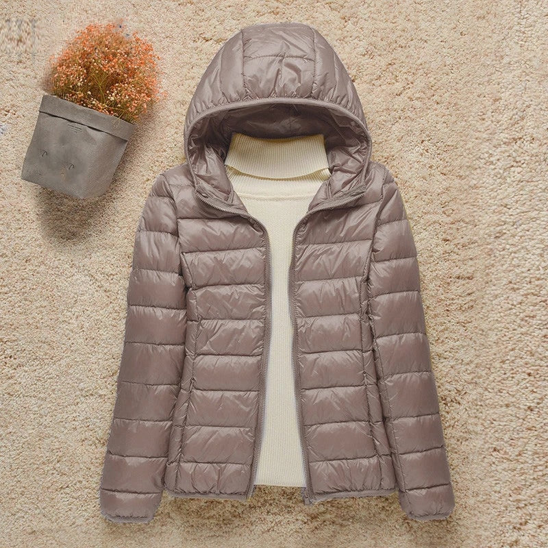 Chaqueta acolchada gris topo con capucha y cierre frontal abierto, vista completa de mangas y bolsillos.