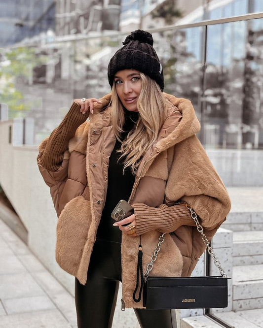 Chaqueta oversize marrón con paneles acolchados, amplias zonas de acabado efecto borreguito y capucha, llevada abierta sobre un conjunto negro.