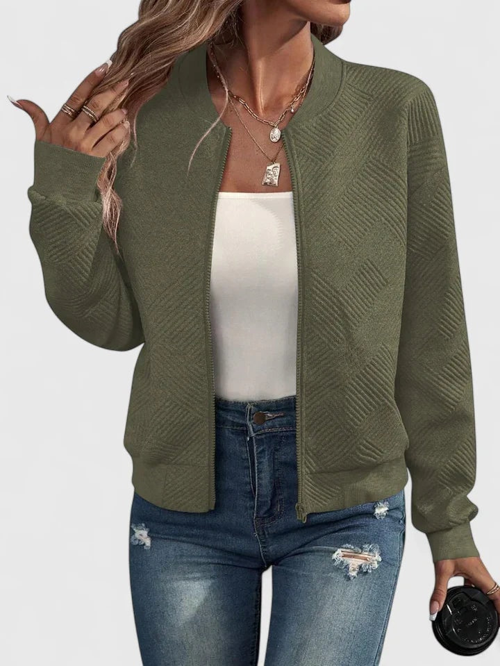 Chaqueta bomber verde oliva con diseño geométrico en relieve, cuello redondo y mangas largas con puños ajustados.