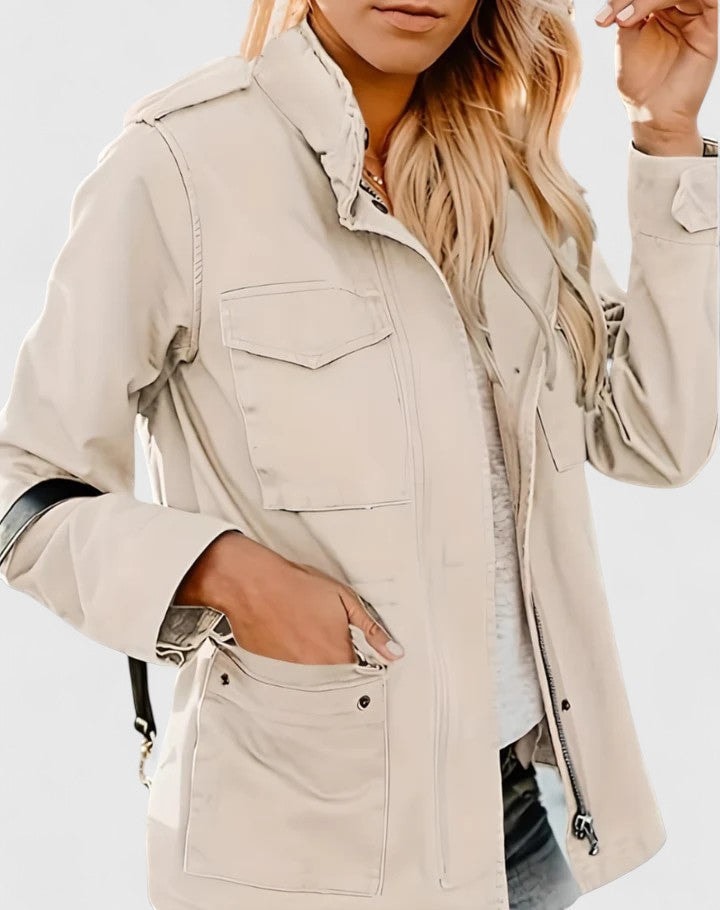 Chaqueta casual color crema con cuello alto y bolsillos amplios, mostrada de frente con una mano dentro del bolsillo.