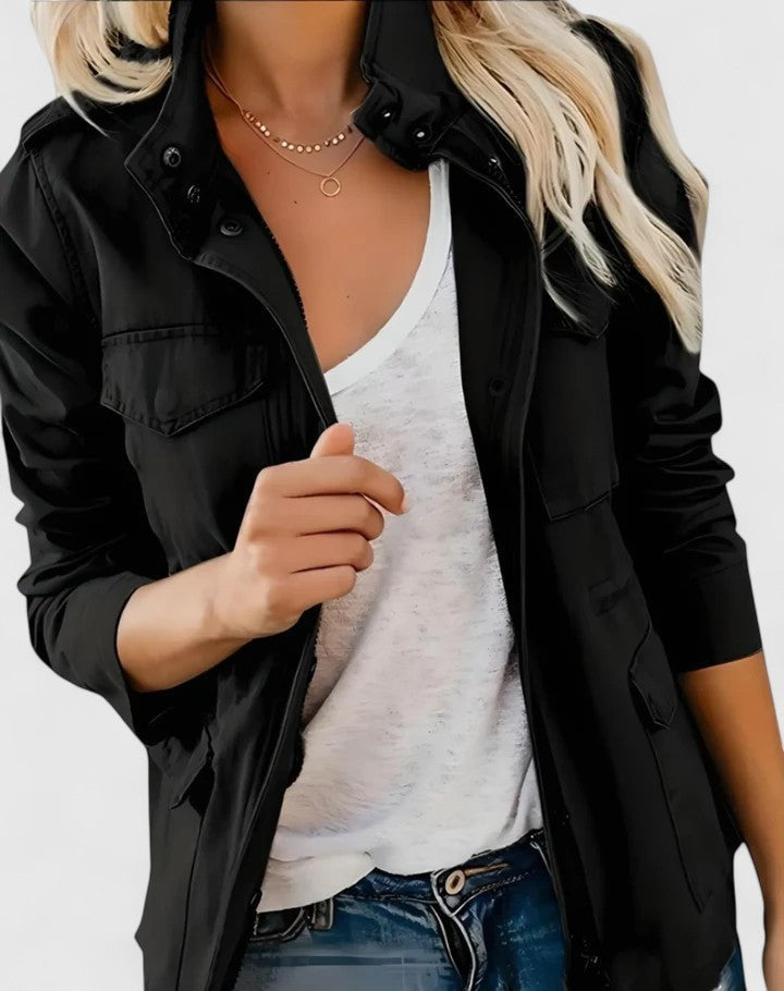 Chaqueta casual negra con cuello alto, cierre delantero y bolsillos frontales, combinada con camiseta blanca.