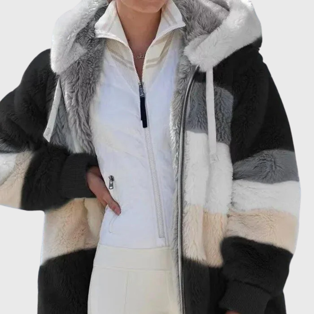 Detalle frontal de la chaqueta negra con franjas grises, blancas y beige, capucha clara y cierre frontal.