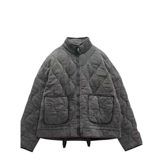 Chaqueta corta acolchada gris oscuro con cuello alto, cierre frontal, acolchado ondulado y dos bolsillos delanteros amplios.