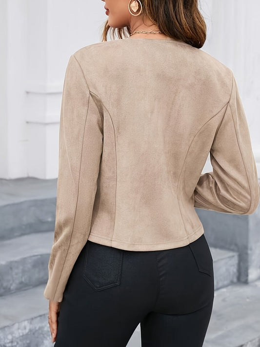 Vista posterior de una chaqueta corta entallada en tono beige, con mangas largas y costuras que definen la cintura.