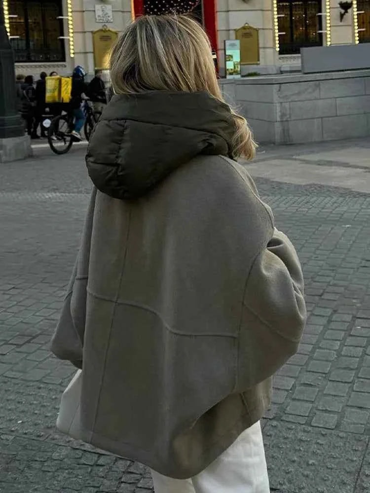 Vista posterior de la chaqueta en movimiento, que resalta su silueta amplia y el volumen del cuello acolchado.