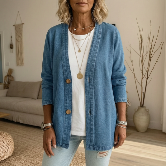 Chaqueta vaquera azul de corte holgado y diseño abierto, con botones delanteros, sobre una camiseta blanca.