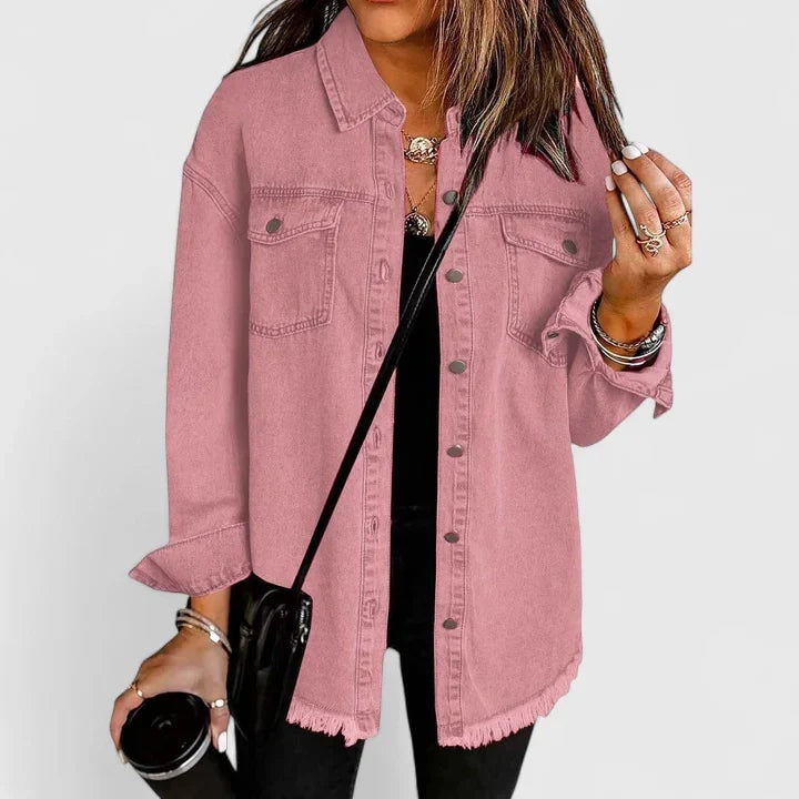 Chaqueta vaquera oversize rosa con cuello camisero, bolsillos delanteros, botones metálicos y bajo deshilachado.