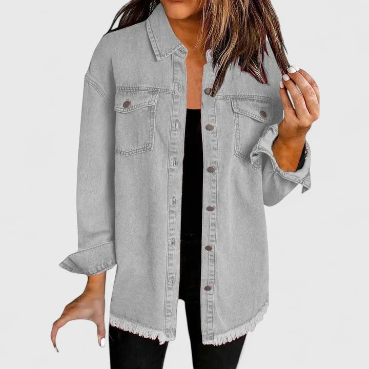 Chaqueta vaquera holgada gris con dos bolsillos delanteros y cierre frontal de botones.