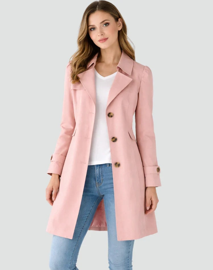 Gabardina entallada rosa con solapas marcadas, botones frontales y cinturilla integrada en los puños.