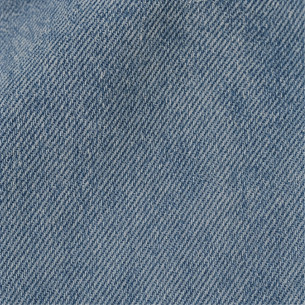 Primer plano de la textura visible y el tono azul del tejido de los jeans.