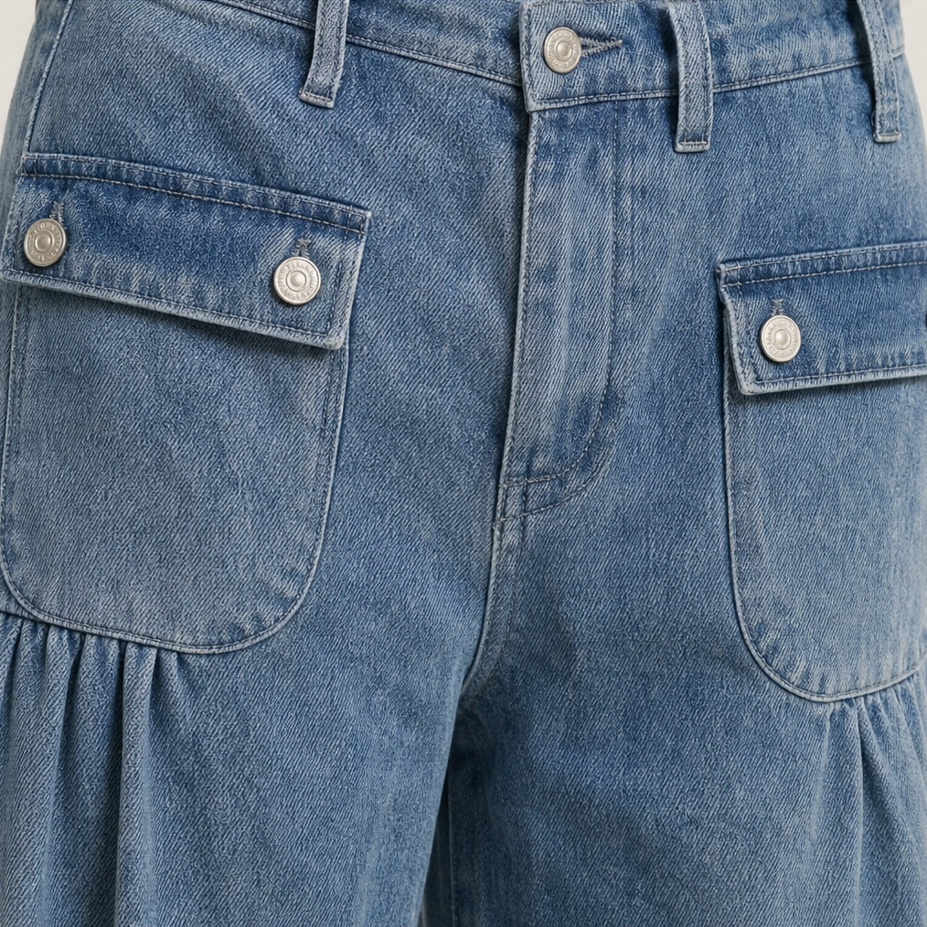 Detalle frontal de los jeans con cierre de botón, trabillas y bolsillos aplicados con solapa.