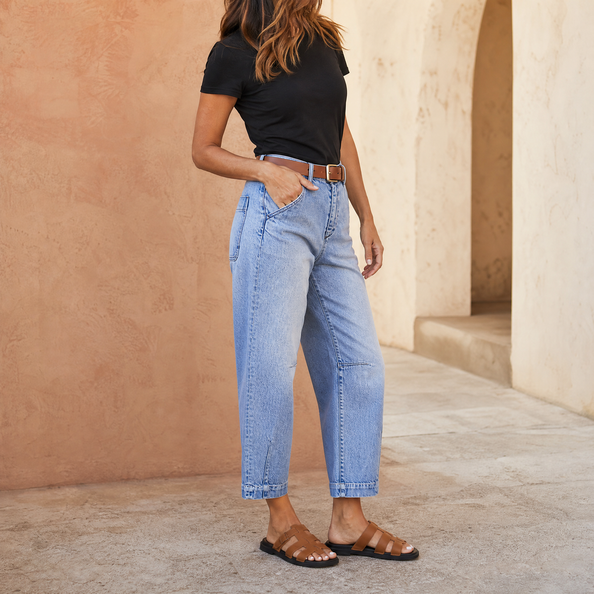 Vista de cuerpo entero de los jeans Marga combinados con camiseta negra y sandalias, destacando su silueta amplia y cintura alta.