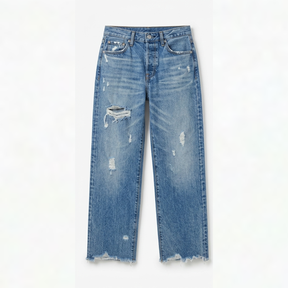 Vista frontal de los jeans rectos cropped azules con desgarrados más marcados en la parte superior de las perneras.