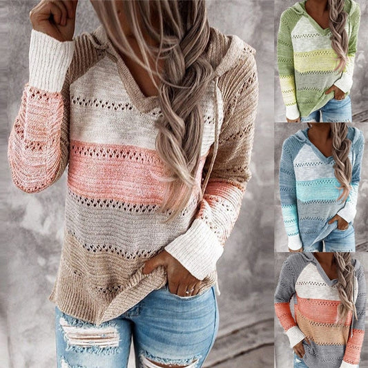Jersey con capucha en tonos beige, rosa y gris, con bloques horizontales y franjas caladas, mostrado de frente con vaqueros.