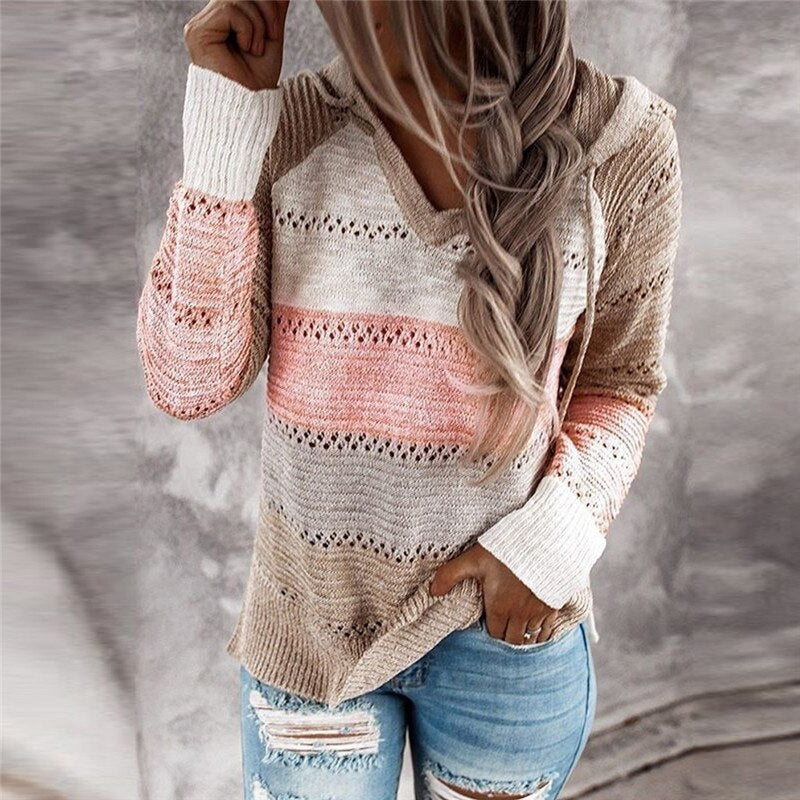 Vista frontal de un jersey con capucha beige y rosa, con escote en V, franjas caladas y bajo ligeramente asimétrico.