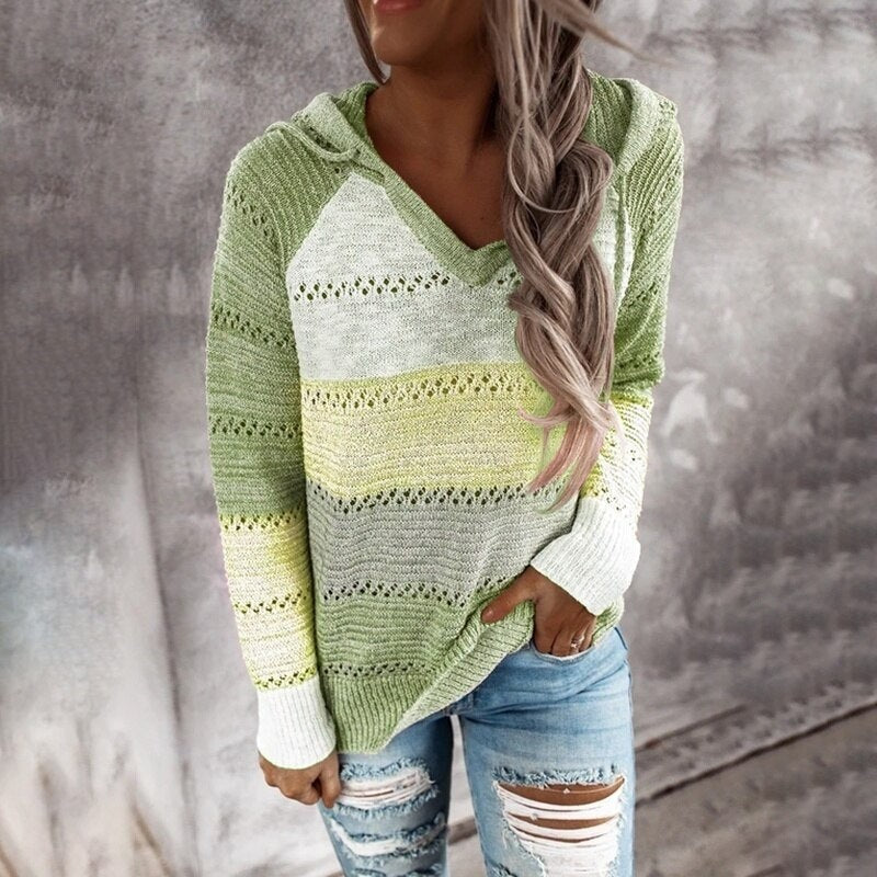 Jersey con capucha en tonos verde y amarillo pálido, con paneles horizontales calados y mangas largas de puño blanco.