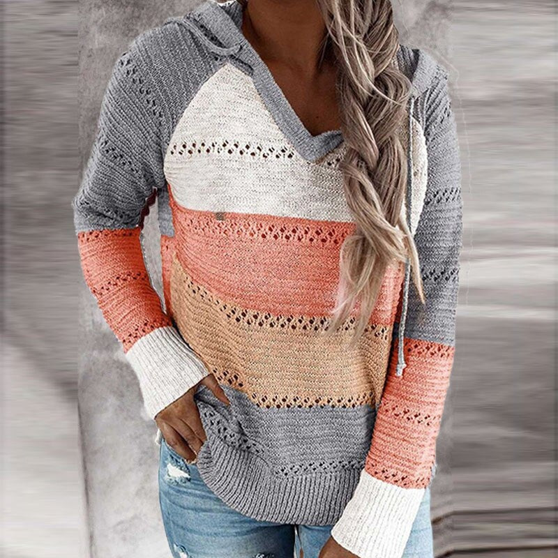 Jersey con capucha gris, coral, beige y blanco, con franjas caladas y bloques de color destacados en el torso y las mangas.