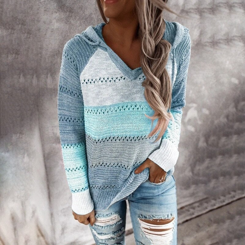 Jersey con capucha en tonos azul y turquesa, con bloques horizontales, detalles calados y puños blancos.