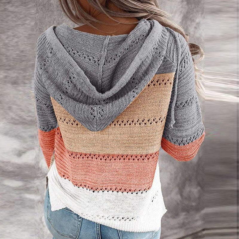 Vista trasera del jersey con capucha gris, beige, coral y blanco, que muestra la capucha amplia y los bloques de color en la espalda.