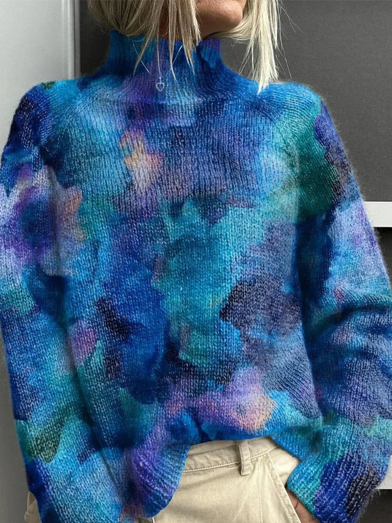 Jersey holgado de cuello alto con estampado abstracto en tonos azules, turquesas y morados.