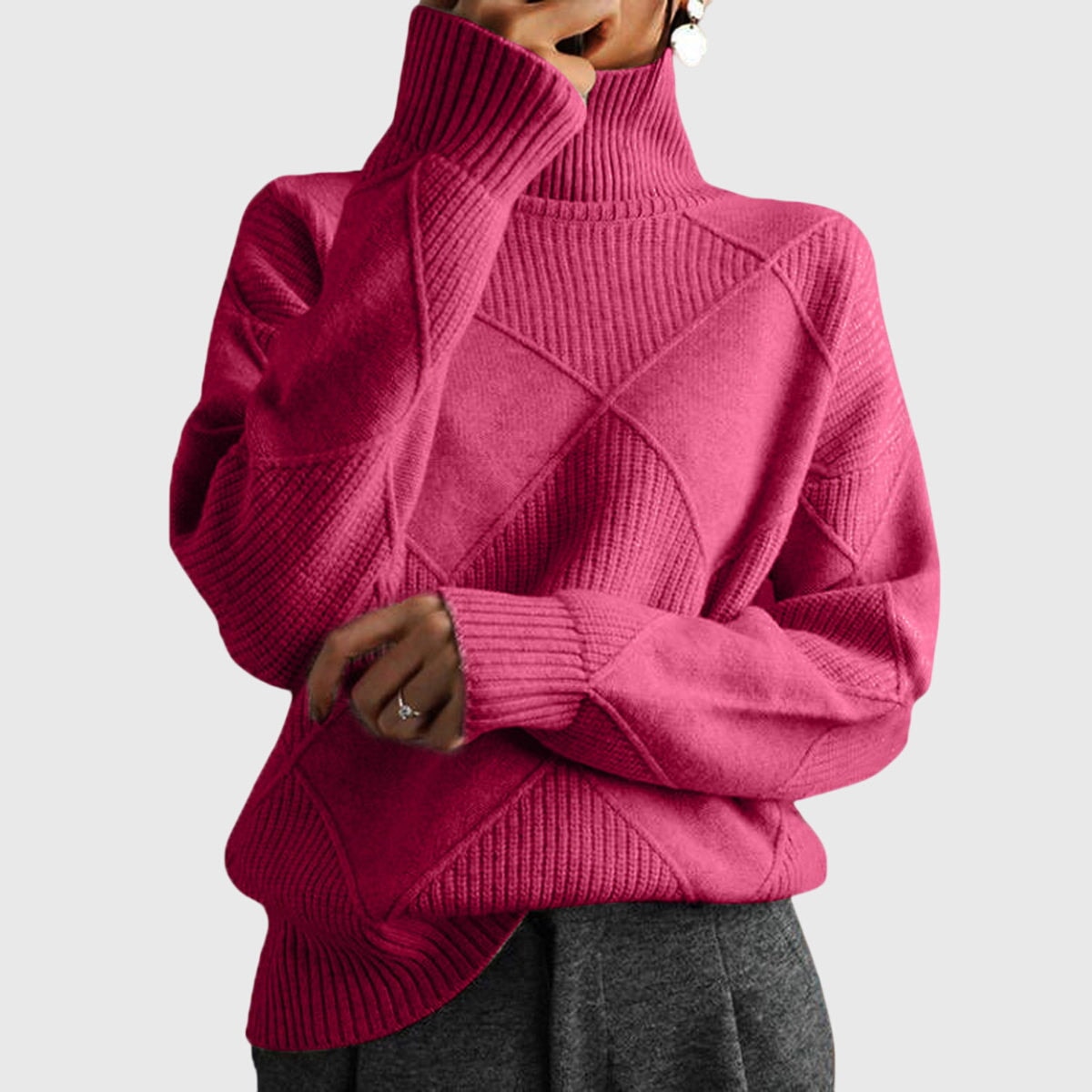 Jersey rosa fucsia de cuello alto, con diseño geométrico en relieve, mangas largas y puños acanalados.