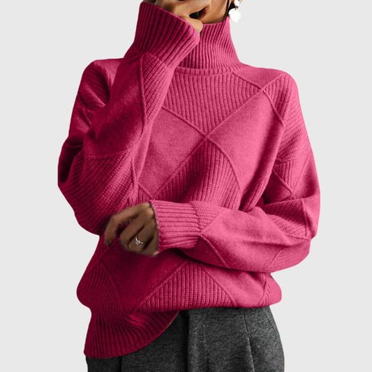 Jersey rosa fucsia de cuello alto, con diseño geométrico en relieve, mangas largas y puños acanalados.