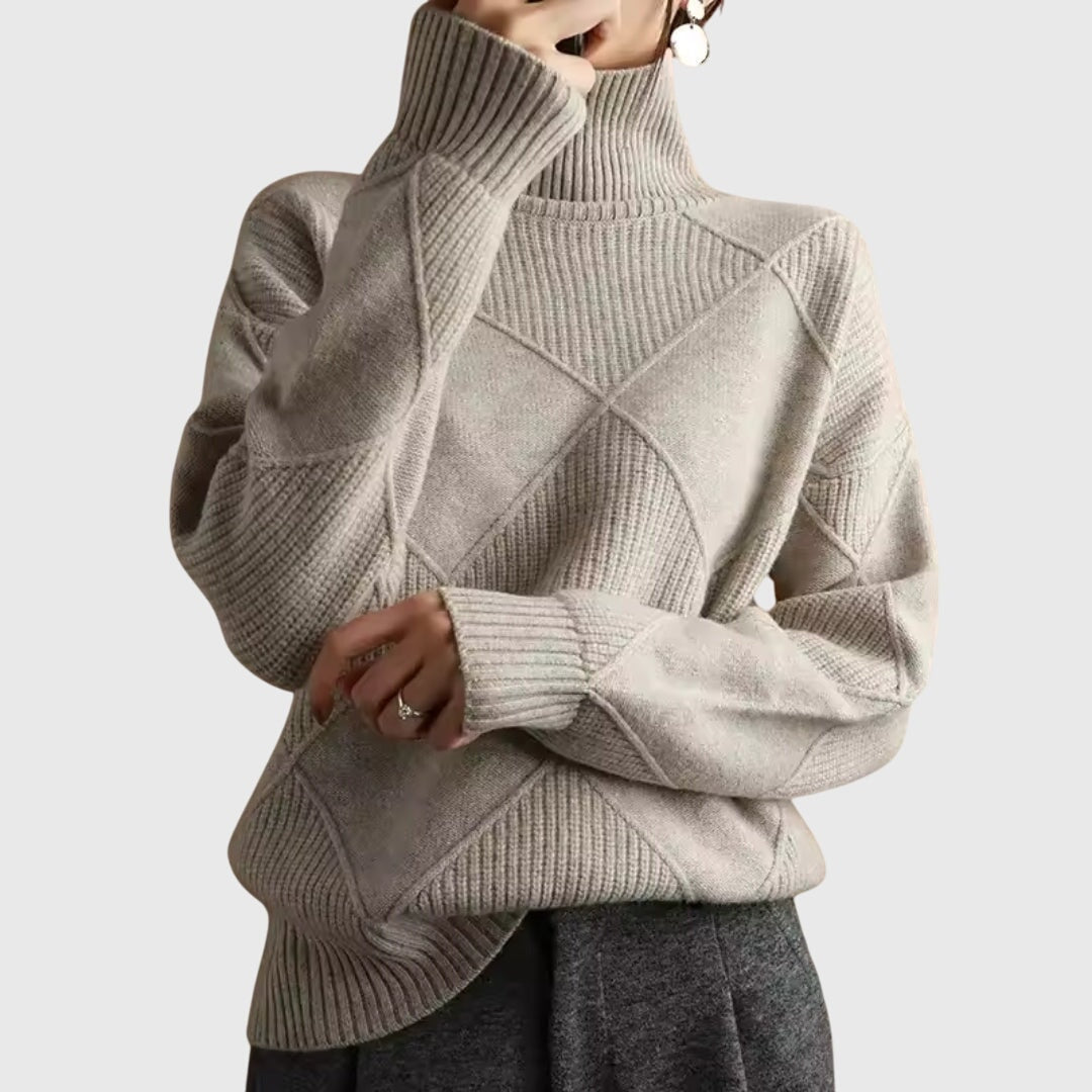 Jersey beige claro de cuello alto con diseño geométrico en relieve, mangas largas y silueta relajada.
