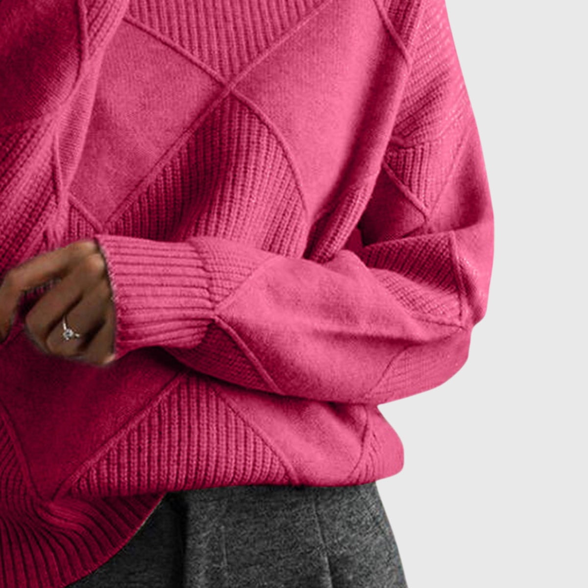 Detalle del jersey rosa fucsia que muestra el relieve geométrico del torso, la manga larga y el puño acanalado.