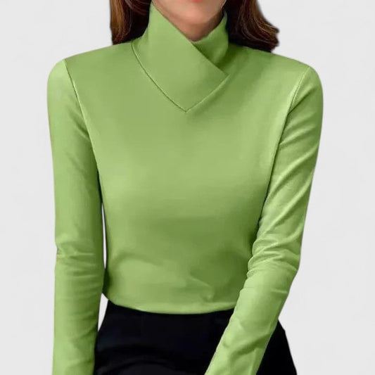 Jersey verde de manga larga con cuello cruzado elevado, combinado con una prenda inferior negra.