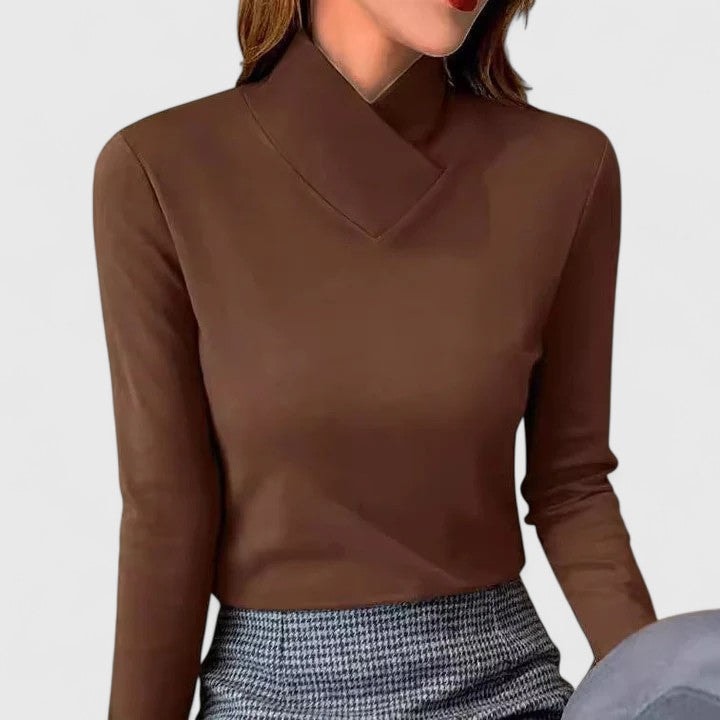Jersey marrón de manga larga con cuello cruzado, combinado con una falda de estampado de cuadros.