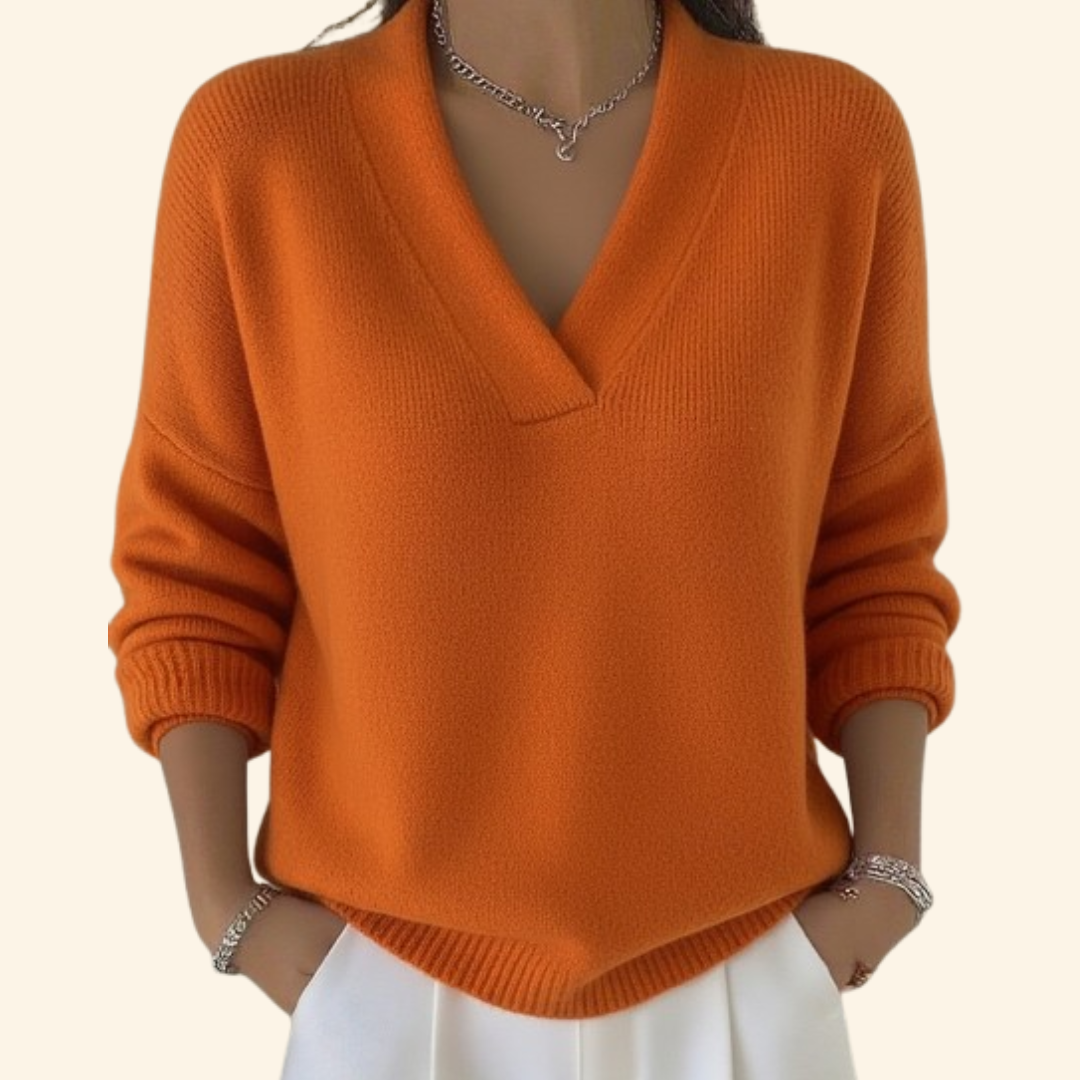 Jersey naranja de cuello en V y corte holgado, con puños ajustados y bajo acanalado en punta.