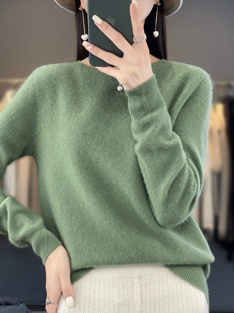 Jersey verde salvia de cuello redondo y corte relajado, combinado con pantalón claro.