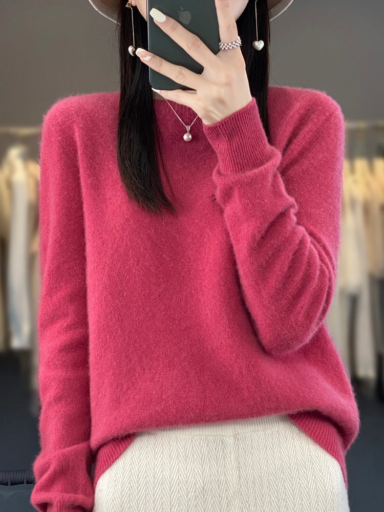 Jersey fucsia de silueta holgada, cuello redondo y manga izquierda recogida.