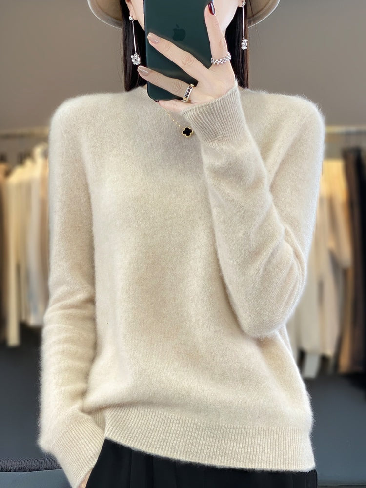 Jersey crema de corte relajado y cuello redondo, combinado con pantalón negro.