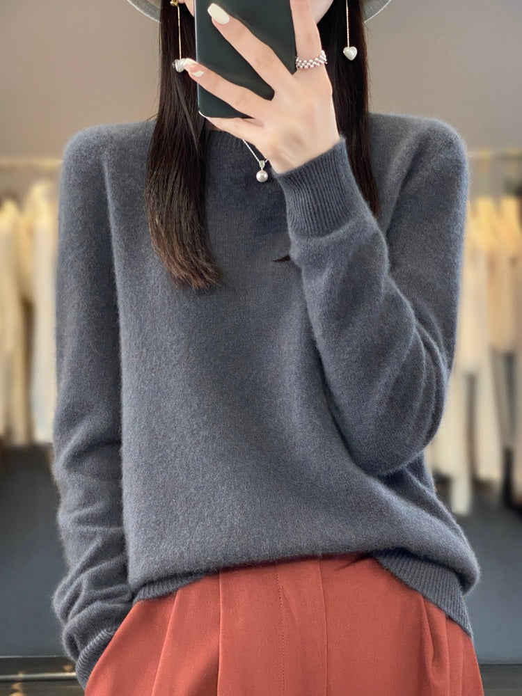 Jersey gris antracita de cuello redondo, llevado con pantalón color teja.