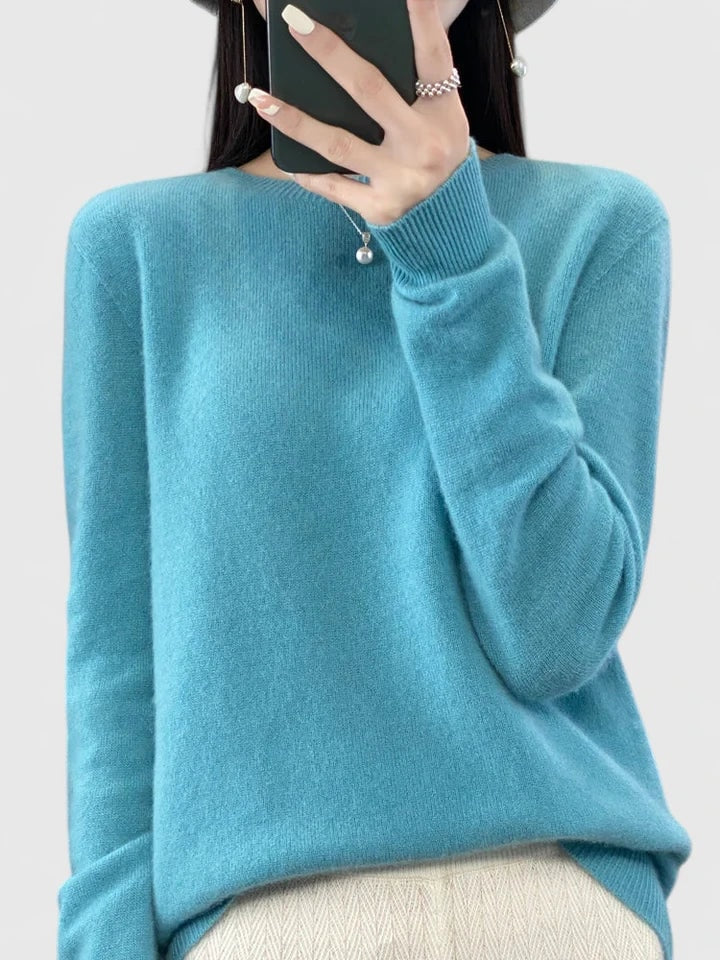 Jersey celeste de corte relajado sobre fondo claro, con el bajo curvado sobre un pantalón blanco.
